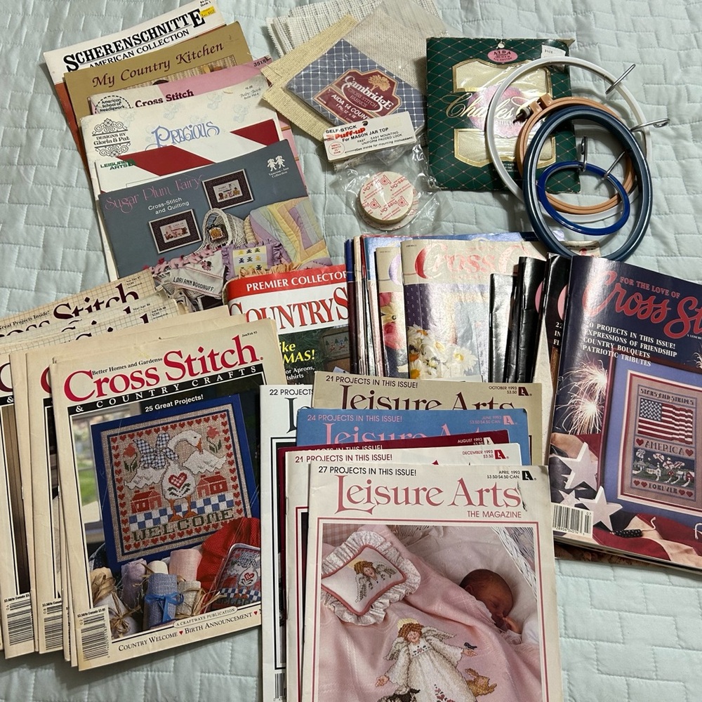 Cross Stitch magazines, pattern books, hoops, and fabric.